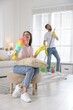 © New Africa - Spring cleaning. Couple having fun and tidying up room together at home
