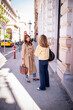 © sepy - Two stylish female friends talking on a sunny city street, urban lifestyle and friendship concept