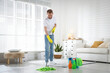 © New Africa - Spring cleaning. Man tidying up floor with mop at home