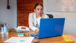© Nicolas Ospina - Thoughtful Businesswoman Working on Laptop at Office Desk During Meeting Preparation.