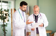 © JackF - Senior and adult male doctors with documents discuss patients medical history. Trainee asks mentor questions, asks for advice, checks treatment tactics, and receives approval for diagnosis.