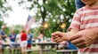 © velikiyzayats - Young boy and father holding sparklers together at outdoor summer celebration with American flag background representing family bonding and patriotic holiday joy