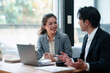 © Crystal - Two young asian business people actively discussing project ideas and strategies during a professional team meeting