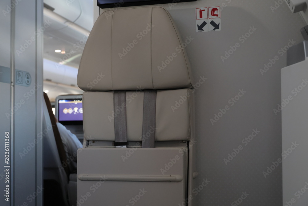 Folded flight attendant jumpseat inside a commercial airplane cabin ...