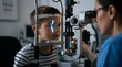 © Pro - Curious young boy in striped shirt receiving precise slit-lamp eye examination from pediatric optometrist in modern clinic, bright blue scanning beam assessing cornea, lens and overall vision health a