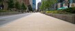 © ckybe - Beige stone walkway blends into the lively downtown street with clear paths and light traffic.