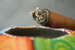 © Towfiqu Barbhuiya  - Cigar resting on colorful ashtray with ash visible