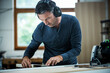 © MACO - Carpenter Measuring, Cutting, and Assembling Wood in a Workshop