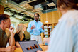 © we.bond.creations - Business team meeting in a modern office, an African American man presenting data and discussing strategy with colleagues