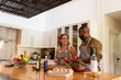 © Rawpixel.com - Two people cooking together in a modern kitchen, smiling and chatting.