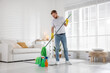 © New Africa - Spring cleaning. Man tidying up floor with mop at home