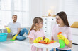 © New Africa - Spring cleaning. Happy family tidying up room together at home