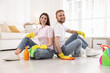 © New Africa - Spring cleaning. Happy couple with detergents sitting on floor at home