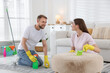 © New Africa - Spring cleaning. Couple tidying up room together at home
