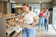 © JackF - Female buyer chooses laminate flooring in a hardware store