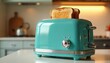 © Vadym - Turquoise retro toaster makes golden toast on clean kitchen counter. Warm light shines on appliance for breakfast. Old style gadget offers fresh bread slices.