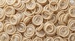 © ProNoJoy - Abundant pile of rolled latex condoms arranged in a dense pattern featuring soft lighting and neutral tones for sexual health and contraception concepts