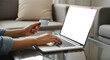 © Lutfor - Woman typing on laptop while holding coffee cup on glass table indoors