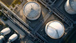 © Oleksiy - Top down aerial view slowly tracking over an oil refinery with large, circular storage tanks and an intricate network of pipelines, illustrating the scale of the global energy industry