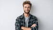 © Renderly - Handsome man with a beard smiles confidently with arms crossed in front of a white wall