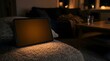 © Hamburatan - Digital tablet with blank screen resting on a couch in a cozy home at night