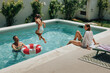 © bernardbodo - Family playing and relaxing by swimming pool