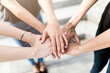 © Westend61 - Close-up of three women stacking their hands