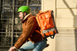 © Oscar - Courier on bicycle delivering food in urban city