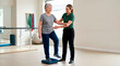 © Xenia - Physiotherapist assisting a senior woman with balance training exercises on a cushion. Older female patient doing fall prevention and mobility workouts in a rehabilitation clinic