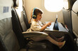 © SISMIZ - Child traveling on airplane watching tablet with headphones