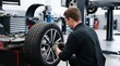 © StocksJust4You - Mechanic repairing car tire inside automotive workshop, focused maintenance work, vehicle service industry, transportation repair and mechanical expertise concept
