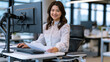 © Maksym - Ergonomic standing desk workstation with adjustable monitor arms, lumbar support chair, wrist rests, and cable management, office worker in focused posture reviewing documents in bright open-plan co