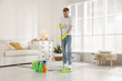 © New Africa - Spring cleaning. Man tidying up floor with mop at home