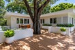 © oksa_studio - Deck patio of a modern house exterior with a large garden tree and green terrace