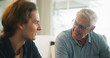 © peopleimages.com - Love, home and elderly father with man for conversation, connection and bonding together on weekend. Senior dad, son or talking on sofa with parent for advice, smile and support in living room