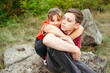 © Cavan - Child girl hugging teenager brother during peaceful countryside moment