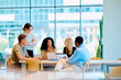 © we.bond.creations - Multiracial business professionals discussing project during informal meeting in contemporary workplace with open plan design