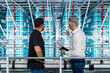 © VISTA by Westend61 - Businessman pointing at storage rack and explaining coworker in industry
