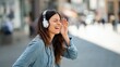 © Mary - Woman wearing headphones listening to music outdoors in city