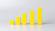 © hardvicore - Minimal wooden yellow bar chart, data visualization bars, business analytics and KPI improvement concept, financial growth and performance tracking theme. Close-up.