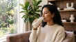 © Tsalsa - Young woman drinking a healthy plant based milk beverage at home.