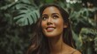 © 锴 张 - Smiling woman with long dark hair surrounded by tropical green foliage, natural beauty portrait with radiant skin, serene expression and soft outdoor lighting in lush botanical setting.