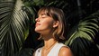 © 锴 张 - Relaxed woman enjoying warm sunlight with closed eyes among tropical green leaves, natural beauty portrait with serene expression, soft shadows and peaceful summer atmosphere.