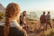 © Marko Geber - Friends hiking with trekking poles on coastal trail at sunset