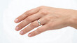© Muhammad - A hand displays a shiny metal ring on the finger against a plain background