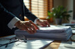 © Pete - Man in suit sorts through large stack of papers on office desk. Eyeglasses rest nearby. Sunlight streams through blinds. He is concentrating on his work.