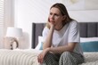 © New Africa - Menopause. Depressed woman on bed at home, space for text