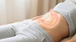 © praewpailyn - Stomach health concept showing gastric digestion process with glowing stomach illustration on person lying down in comfortable clothes promoting digestion and wellness