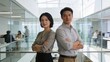 © ibhonk - Business professionals stand back to back with arms crossed inside a modern open office.