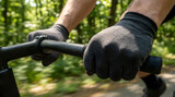 Close-up of hands wearing black cycling gloves gripping handlebars on a sunny day
